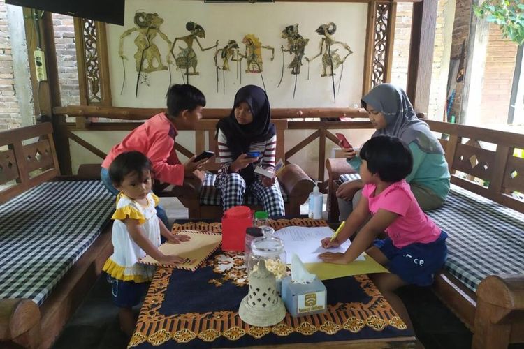 Anak-anak sekolah belajar daring menumpang di Pawon Luwak Coffee di sekitar Candi Pawon Mungkid, Kabupaten Magelang.