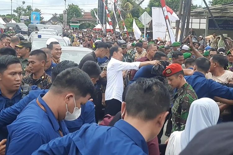 Presiden Joko Widodo membagi-bagikan kaus kepada masyarakat usai meresmikan inpres jalan daerah ruas Blora - Wirosari di Blora, Jawa Tengah, Selasa (23/1/2024)