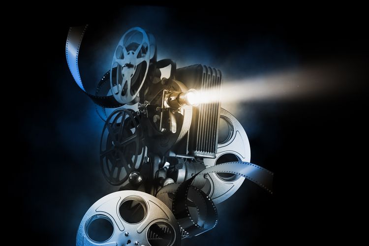 Ilustrasi sorot lampu proyektor dalam gedung bioskop, salah satu contoh efek Tyndall di kehidupan sehari-hari.