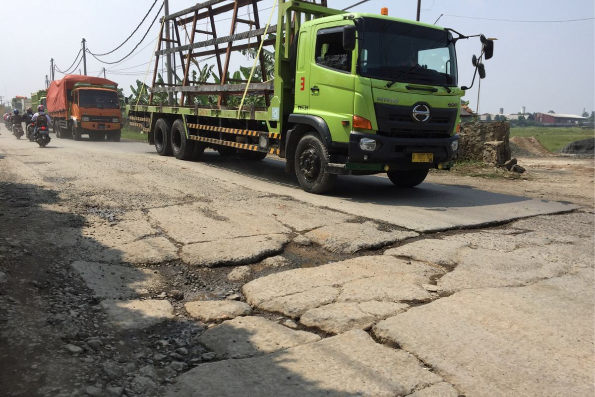 Kondisi Jalan Raya Parung Panjang menuju ke lahan milik Pemerintah Provinsi DKI Jakarta di Desa Ciangir, Kecamatan Legok, Kabupaten Tangerang, Selasa (25/7/2017). Banyaknya jalan berlubang dan sebagian yang telah ditambal menyebabkan pengendara tidak nyaman untuk melintas.