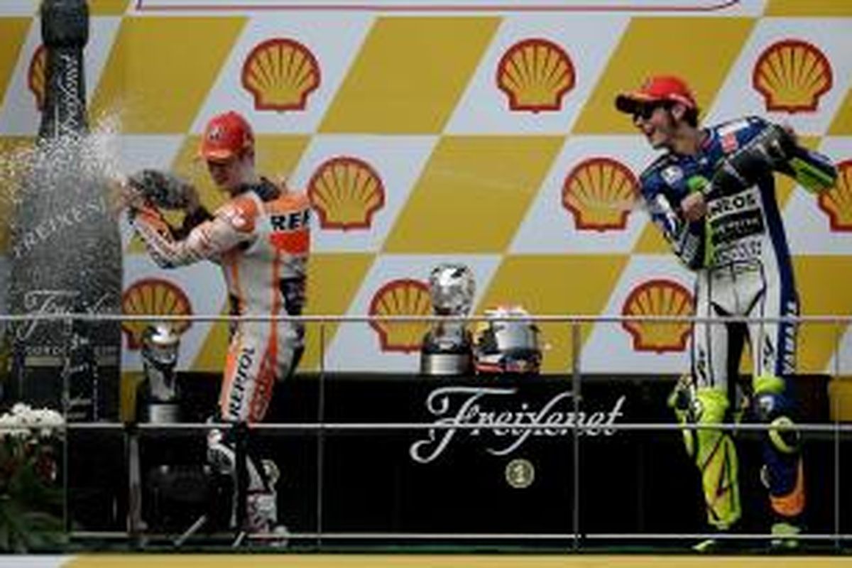 Dani Pedrosa (kiri) dan Valentino Rossi melakukan perayaan di atas podium setelah MotoGP Malaysia berakhir, Minggu (25/10/2015).