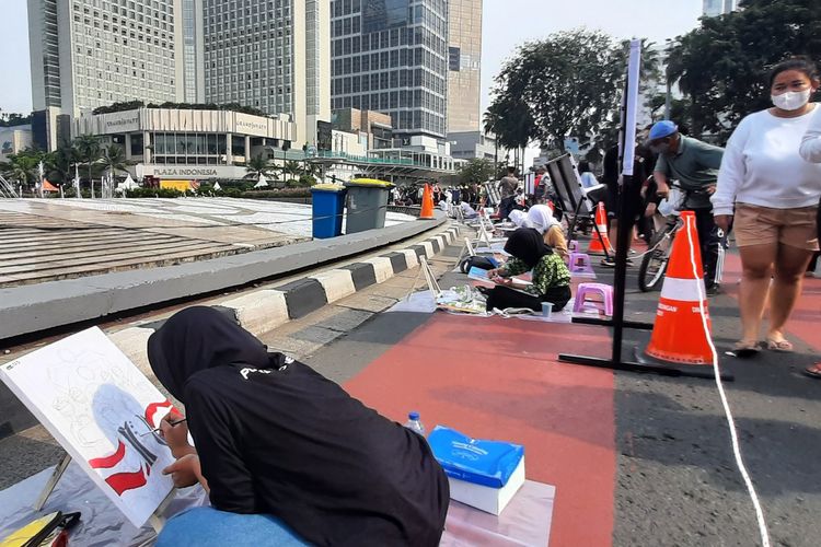 Ratusan pelukis berkumpul saat car free day (CFD) di Bundaran Hotel Indonesia (HI), Jakarta Pusat, Minggu (18/9/2022) pagi.  Mereka unjuk kebolehan untuk memeriahkan Hari Lalu Lintas Ke-67 Bhayangkara.