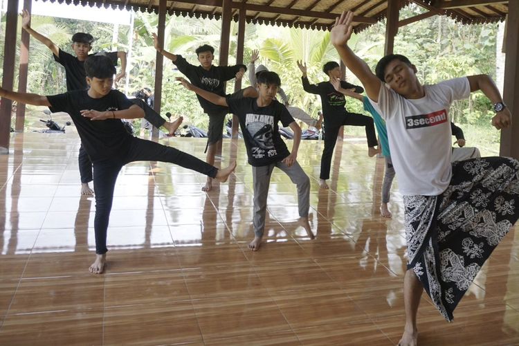 
Irfan Efendi (17), salah satu anak Kampung Batara terlihat melatih teman-temannya untuk menari di sebuah bangunan berdinding bambu di Kampung Papring, Kelurahan Kalipuro pada Minggu (13/8/2023).
