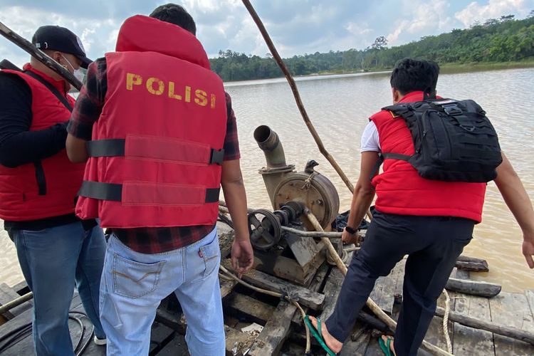 Polisi saat menenggelamkan rakit yang digunakan untuk penambangan emas ilegal di Dam Betuk, Merangin, Jambi, Senin (18/7/2022).