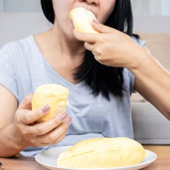 Ilustrasi orang makan durian.