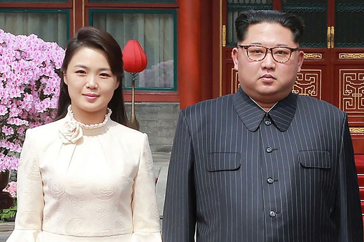 Foto yang dirilis kantor berita Korea Utara KCNA pada 28 Maret 2018 memperlihatkan Kim Jong Un berpose bersama istrinya Ri Sol Ju saat berkunjung ke Beijing, China.
