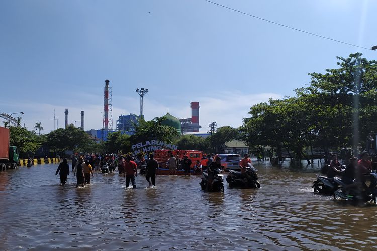 Warga mulai mengambil sepeda motor yang tenggelam karena rob. Selasa (24/5/2022)