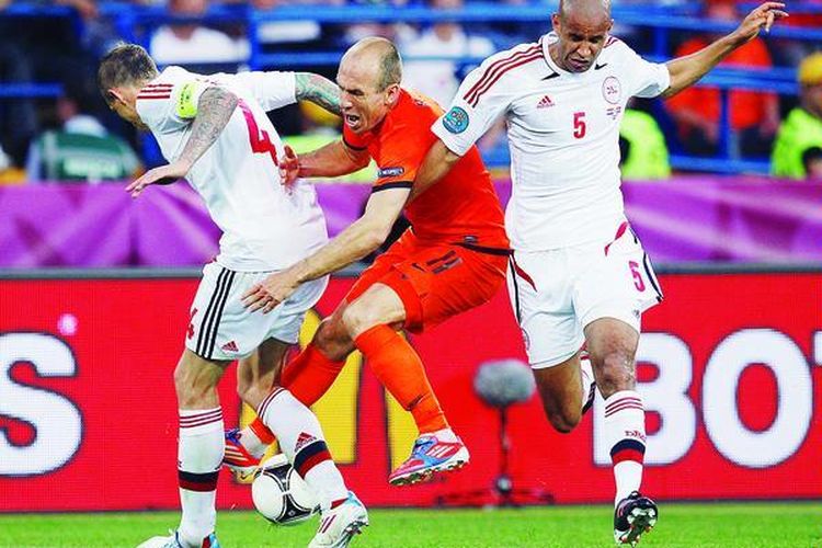 Pemain sayap Belanda, Arjen Robben, ditekel bek tengah  Denmark Daniel Agger  (kiri) dan Simon Busk Poulsen dalam laga Grup B Piala Eropa 2012  di Kharkiv, Ukraina, Sabtu (9/6). Di luar dugaan, Belanda kalah 0-1 di tangan tim Dinamit Denmark.