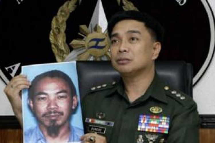 Seorang pejabat kepolisian Filipina menunjukkan foto Zulkifli bin Hir. 