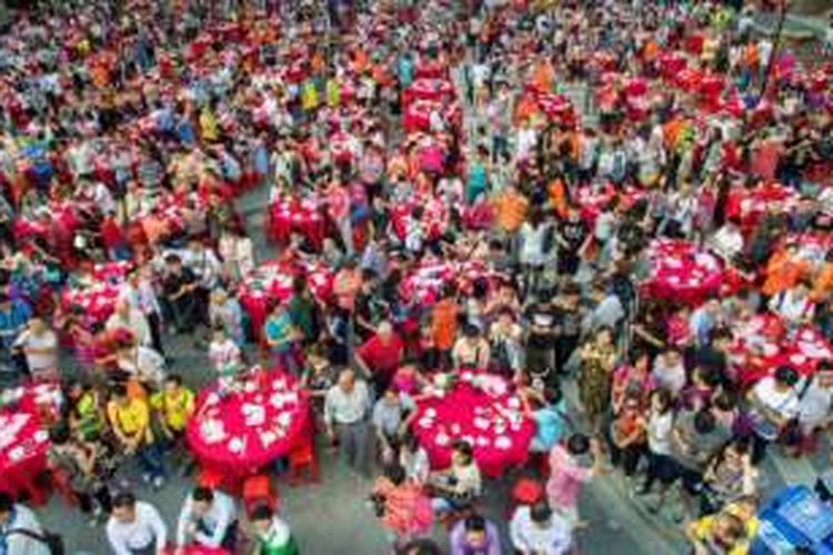 Sebayak 15.000 warga desa Yangji, Guangzhou yang digusur menghadiri pesta makan malam yang digelar di bekas jalanan desa sebelum menghuni apartemen baru.