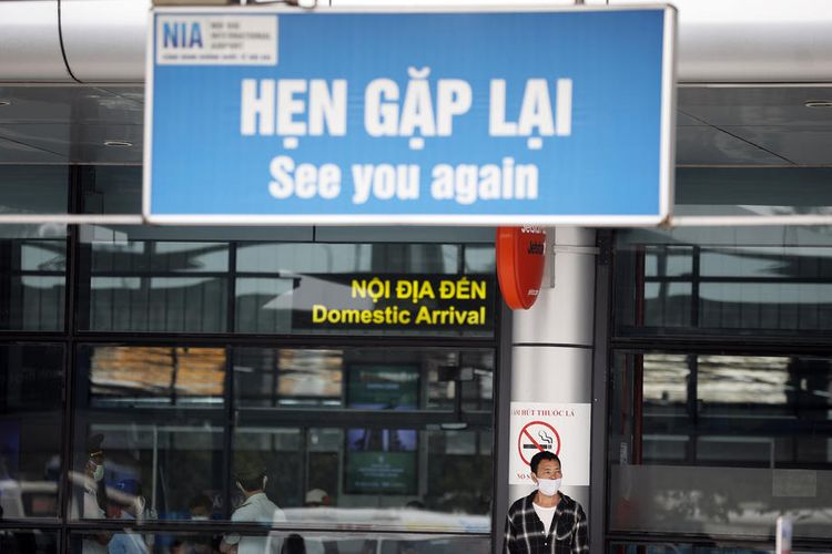 Seorang pria berdiri memakai masker di Bandara Internasional Noi Bai, Hanoi, Vietnam, 20 Maret 2020.
