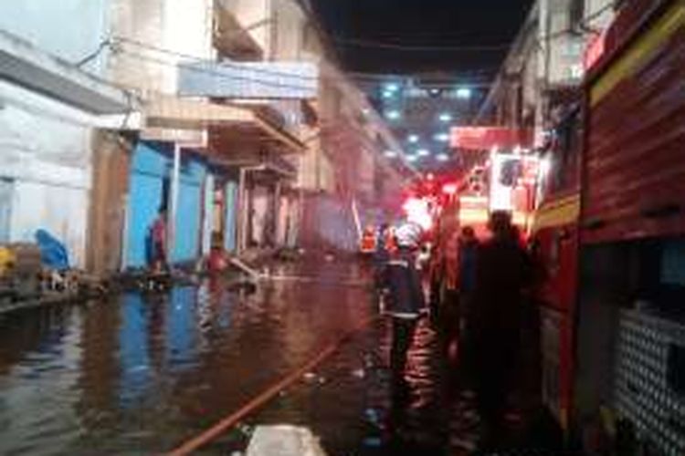 Proses pembasahan kebakaran ruko di komplek Pasar Atom Surabaya, Senin (11/4/2016) malam.