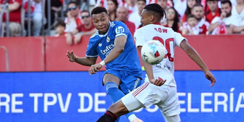 Kylian Mbappe menembak melewati Djibril Sow dalam pertandingan sepak bola Liga Spanyol antara Sevilla vs Real Madrid CF di stadion Sanchez Pizjuan di Seville pada 17 Mei 2026. (Foto oleh CRISTINA QUICLER / AFP)