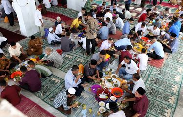 Warga menikmati makanan yang disajikan pada peringatan Maulid Nabi Muhammad SAW di Masjid Jamik Lueng Bata, Banda Aceh, Aceh, Selasa (19/10/2021). Pada setiap perayaan hari kelahiran (maulid) Nabi Muhammad SAW yang berlangsung selama tiga bulan di Aceh, warga selain menyiapkan berbagai makanan dengan menu utama Kuah Beulangong (kari daging sapi atau kambing dengan bumbu khas) untuk dinikmati bersama juga menggelar zikir, menyantuni anak yatim, fakir dan miskin. ANTARA FOTO / Irwansyah Putra/aww.