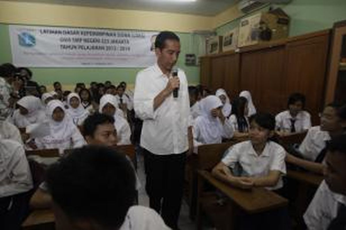 Calon presiden yang juga Gubernur DKI Jakarta, Joko Widodo atau Jokowi, saat mengunjungi SMP Negeri 223, Kampung Gedong, Pasar Rebo, Jakarta Timur, Selasa (18/3/2014). Dalam kunjungannya, Jokowi bertanya kepada para murid mengenai Kartu Jakarta Pintar yang telah dibagikan oleh Pemprov DKI Jakarta. KOMPAS IMAGES/RODERICK ADRIAN MOZES