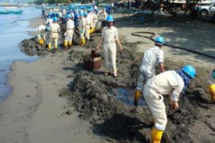 Petugas PT Pertamina Refinery Unit IV Cilacap, Senin (25/5) sore, menggelar pembersihan pantai secara massal di kawasan Pantai Teluk Penyu, Cilacap, Jawa Tengah, yang tercemar minyak. 