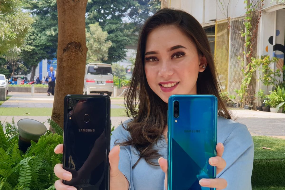 Seorang model menggenggam Galaxy A20s (kiri) dan Galaxy A30s  (kanan).