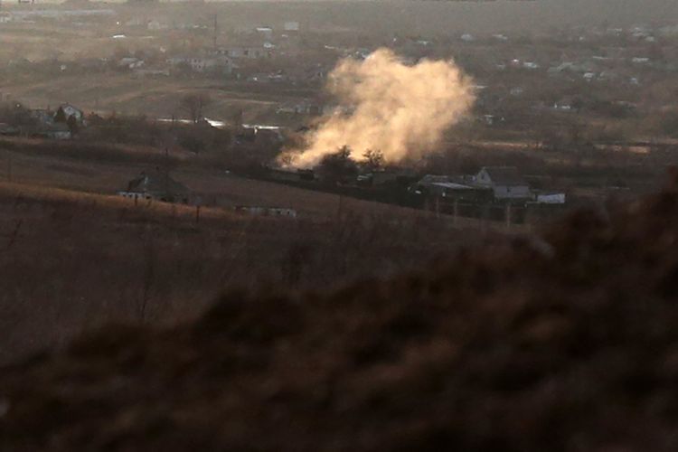 Asap membubung usai ledakan di desa Novohnativka, wilayah Donetsk, tak jauh dari pos militer Ukraina di garis depan melawan separatis yang didukung Rusia, Sabtu (19/2/2022).