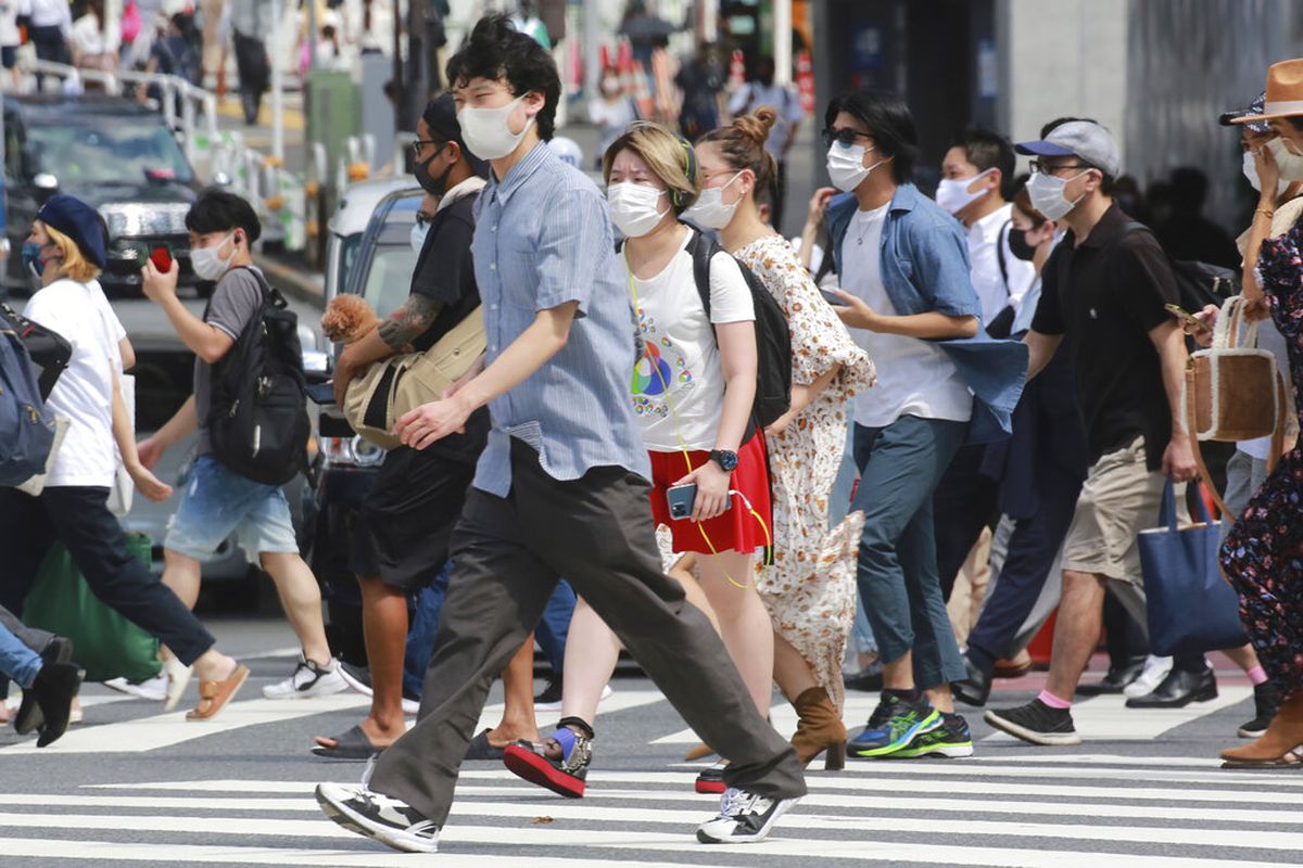 Orang-orang yang memakai masker untuk membantu melindungi diri dari penyebaran virus corona berjalan melintasi persimpangan di Tokyo, Senin, 30 Agustus 2021.