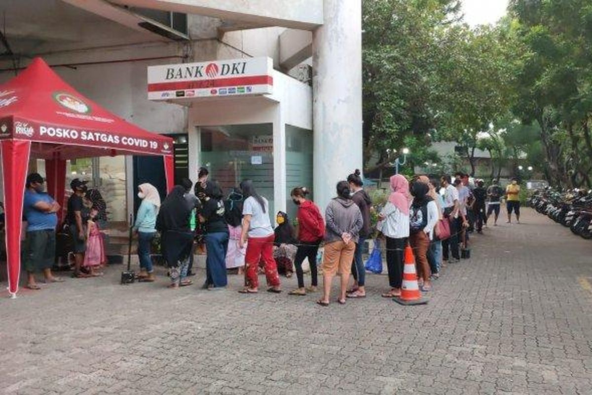 Antrean warga yang ingin mencairkan BST di ATM Bank DKI mengular di Gedung Mitra Praja, Tanjung Priok, Jakarta Utara, Senin (19/7/2021) sore.