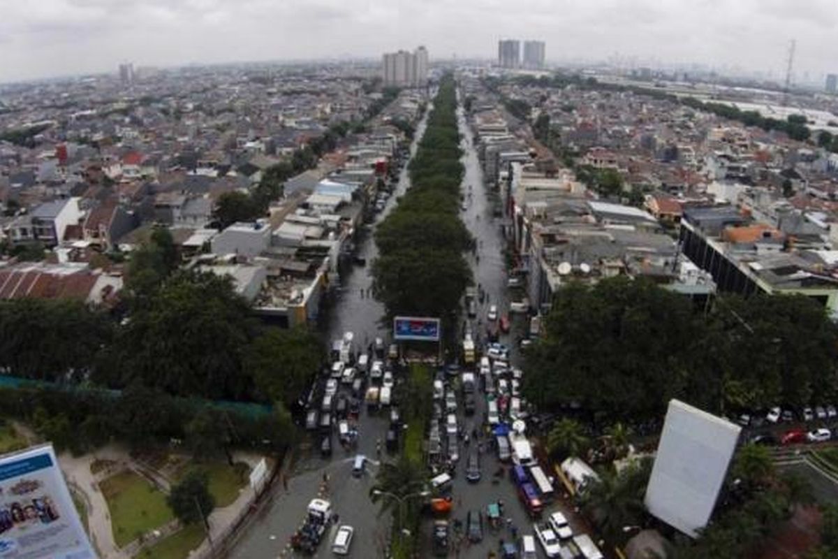 Banjir menggenangi kawasan permukiman dan perekonomian di Kelapa Gading, Jakarta Utara, Selasa (10/2/2015). Jakarta menghadapi masalah penurunan muka tanah. Kondisi itu diperparah oleh semakin minimnya daerah resapan air yang diganti dengan hunian dan gedung-gedung pencakar langit.