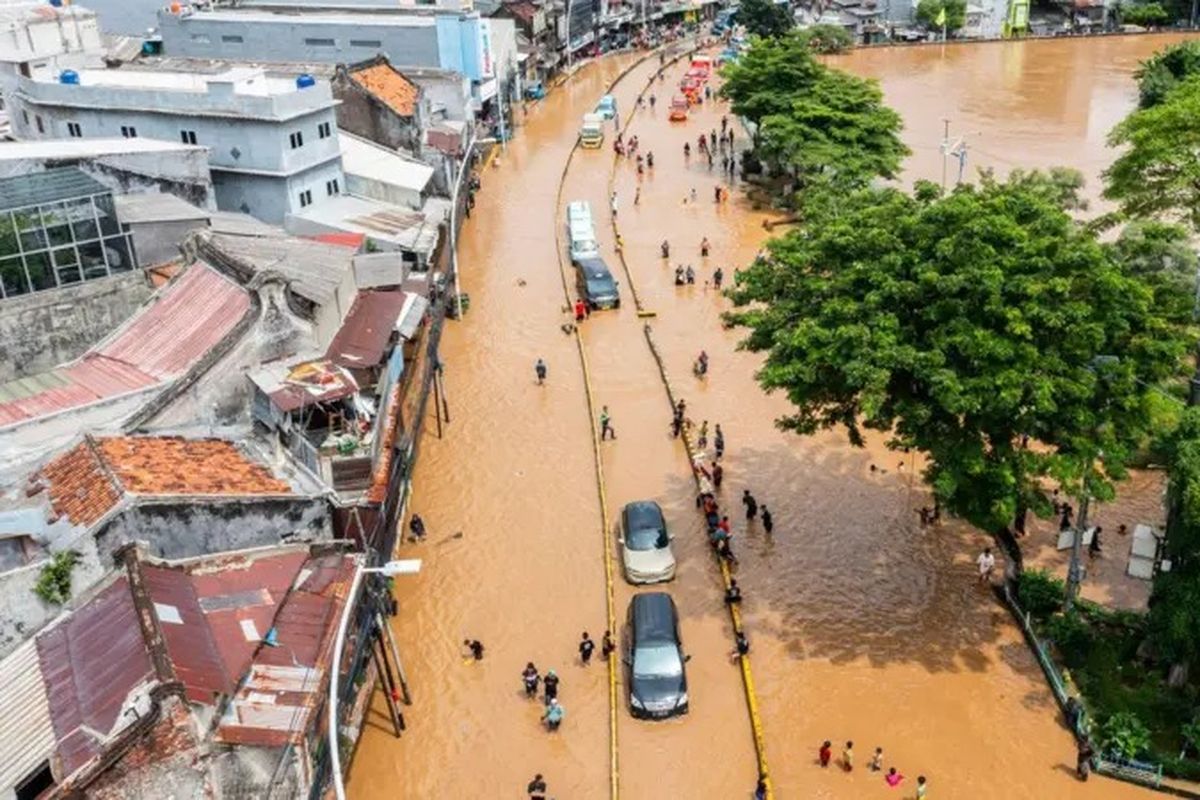 Foto udara sejumlah mobil melintasi banjir akibat luapan air Sungai Ciliwung di Jatinegara, Jakarta, Selasa (04/03).