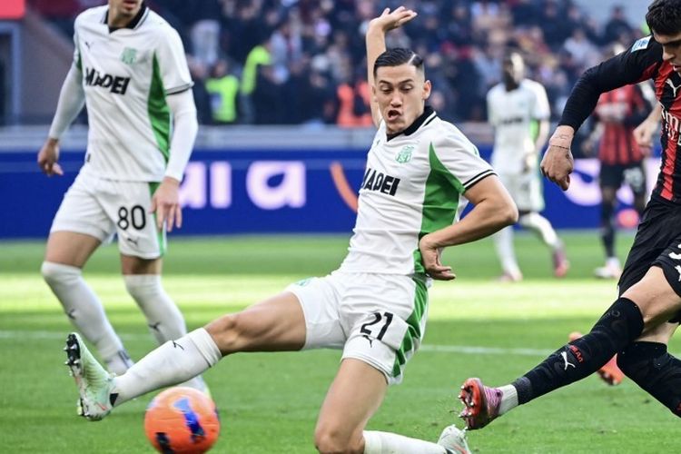Jay Idzes (kiri) mencoba membendung tembakan Davide Bartesaghi (kanan) dalam laga Liga Italia 2025-2026 AC Milan vs Sassuolo di Stadion San Siro, 14 Desember 2025. (Photo by Piero CRUCIATTI / AFP)