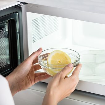 Ilustrasi membersihkan microwave dengan kulit jeruk. 