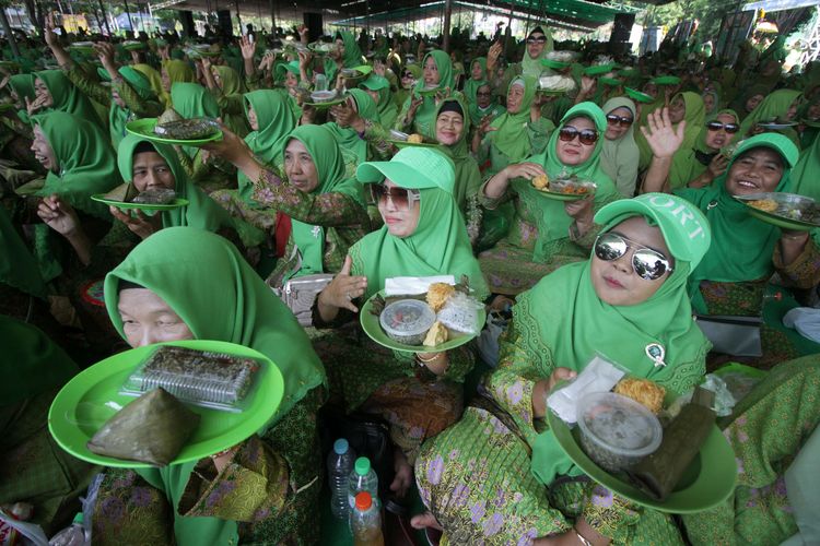 Ibu-ibu Muslimat NU menunjukkan sajian kupang lontong saat peringatan Harlah ke-77 Muslimat NU di parkir timur Gelora Delta Sidoarjo, Jawa Timur, Minggu (28/5/2023). Kegiatan bertema Menguatkan Muslimat Nahdlatul Ulama Dalam Membangun Peradaban tersebut mencatat rekor MURI makan kupang lontong dengan peserta sebanyak 13.000 orang.