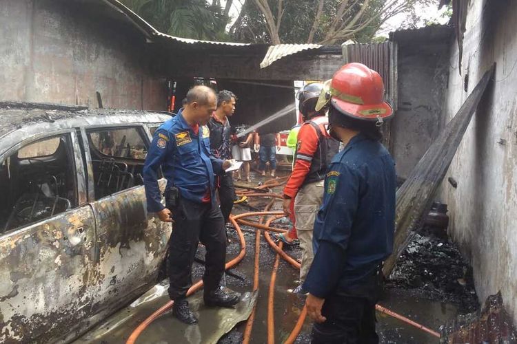 Petugas memadamkan api yang membakar sebuah rumah di Jalan Kenari Raya II, Perumnas Mandala, Deli Serdang pada Sabtu (26/2/2022) siang. Dalam peristiwa itu, seorang ibu dan dua orang anaknya ditemukan tewas dengan kondisi hangus terbakar di kamar mandi.