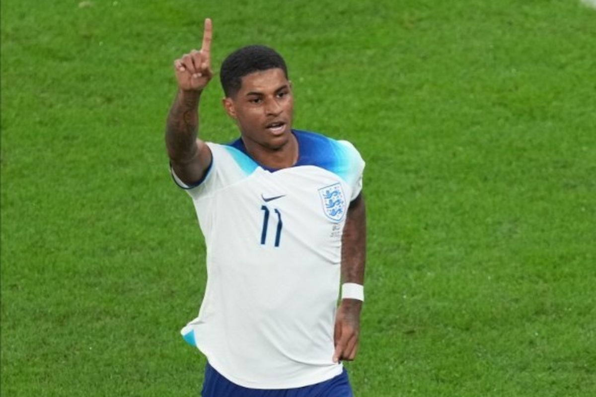 Striker timnas Inggris, Marcus Rashford, melakukan selebrasi seusai mencetak gol ke gawang Wales pada laga Grup B Piala Dunia 2022 yang dihelat di Ahmed bin Ali Stadium, Rabu (30/11/2022) dini hari WIB. Dua gol ke gawang Wales mengantar Rashford ke puncak daftar top skor Piala Dunia 2022. 
