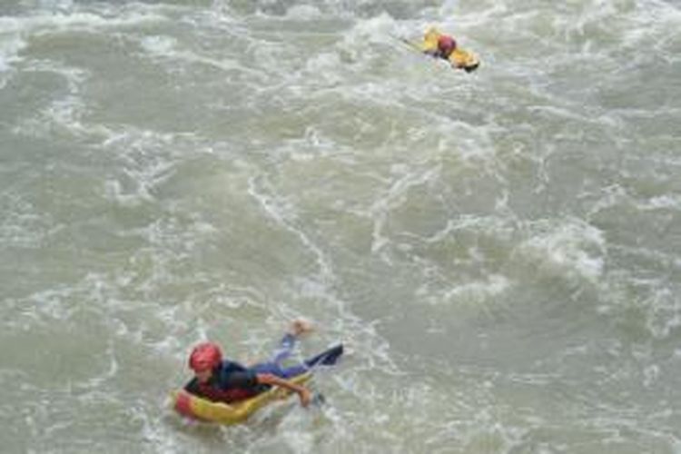 Anak-anak melakukan riverboarding di Sungai Citarum. 