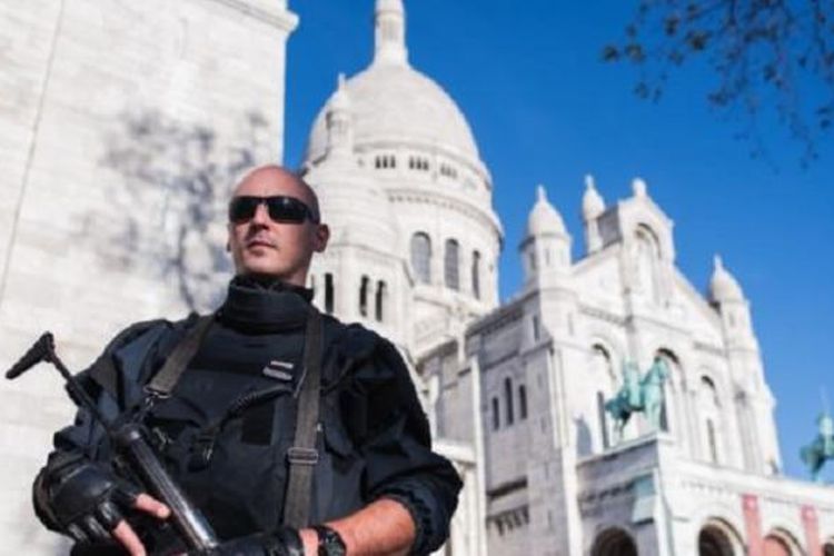 Seorang polisi Perancis mengamankan basilika Sacre Coeur di Paris, Minggu (15/11/2015). Kelompok ISIS mengancam akan menjadikan Washington DC target serangan seperti Paris. 