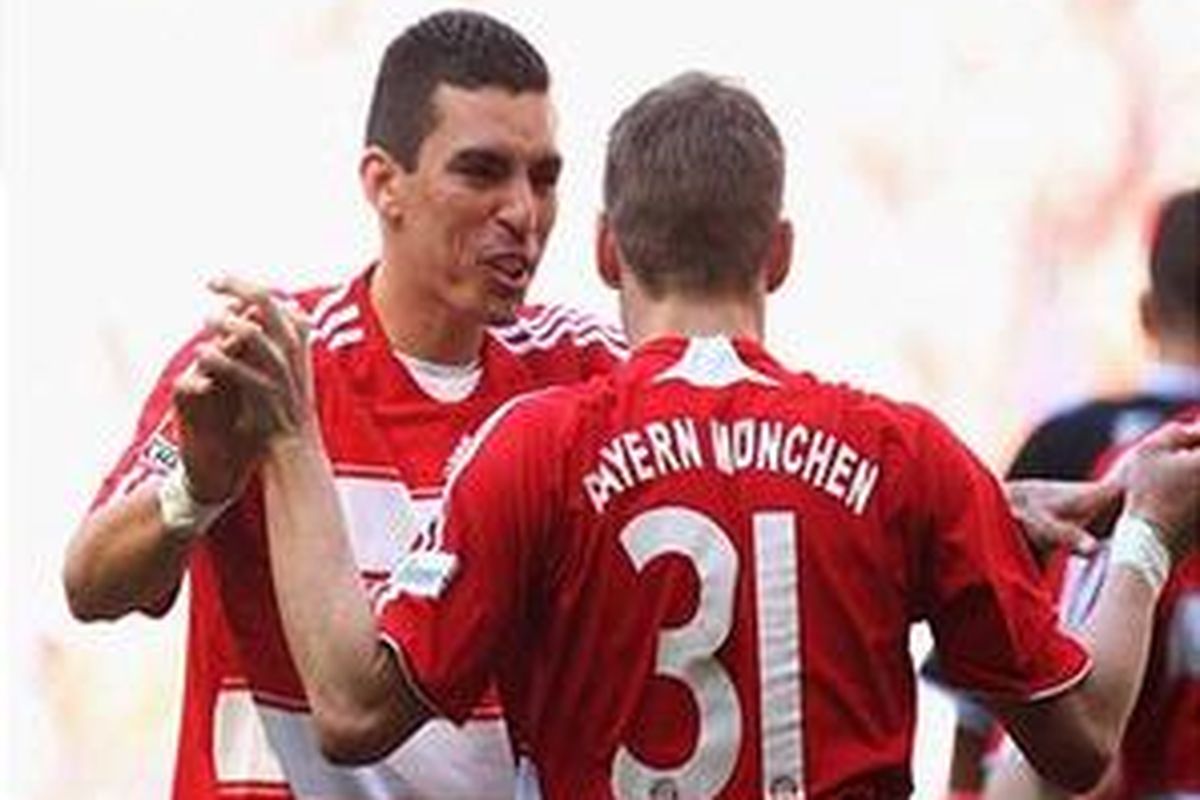 Lucio dan bastian Schweinsteiger merayakan gol. Keduanya mencetak 1 gol, membawa Bayern Muenchen menang 4-0 atas Eintracht Frankfurt.