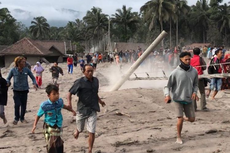 Warga berlarian meninggalkan Kampung Renteng setelah petugas menyampaikan peringatan mengenai munculnya asap di kawasan Gunung Semeru di Kabupaten Lumajang, Provinsi Jawa Timur, Minggu (5/12/2021). (ANTARA/Fiqih Arfani)