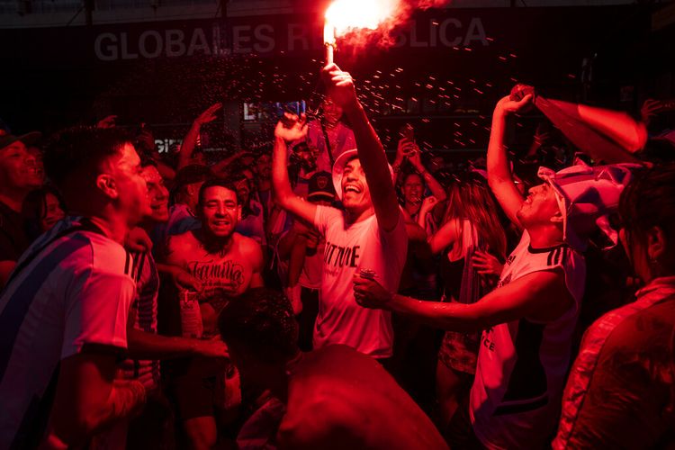Penggemar sepak bola Argentina menyalakan suar merayakan kemenangan tim mereka di Piala Dunia atas Prancis di Buenos Aires, Argentina, Minggu, 18 Desember 2022.