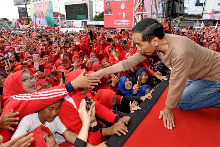 Calon presiden nomor urut 1 Joko Widodo saat bersalaman dengan warga dalam acara jalan sehat di pusat kota Bandar Lampung, Sabtu (24/11/2018).