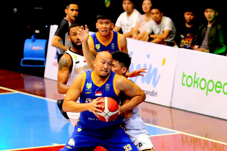 Pemain Satria Muda Pertamina Jakarta Arki Dikania Wisnu usai rebound langsung dijaga ketat pemain Bima Perkasa Jogya saat pertandingan IBL 2023 seri 2 yang berakhir dengan skor 56-67 di GOR Bima Sakti Kota Malang, Sabtu (4/2/2023) sore.