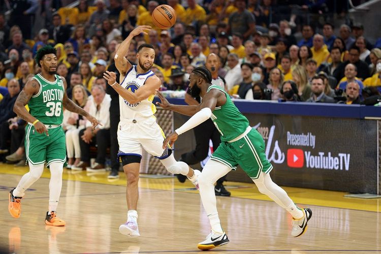 Stephen Curry (30) dari Golden State Warriors mengoper bola dalam penjagaan Jaylen Brown (hijau/7) dari Boston Celtics pada kuarter pertama di Gim 1 Final NBA 2022 di Chase Center pada 02 Juni 2022 di San Fransisco, California.