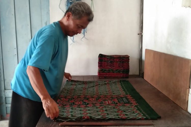 Pekerja sedang melipat kain sarung goyor di perusahaan Botol Terbang, Kota Magelang, Jumat (22/3/2024).