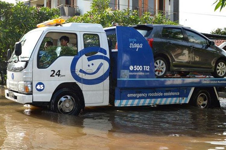 Mobil pelanggan diselamatkan oleh perusahaan Asuransi akibat banjir di Ibukota, Senin-Selasa (9-10/2/2015).