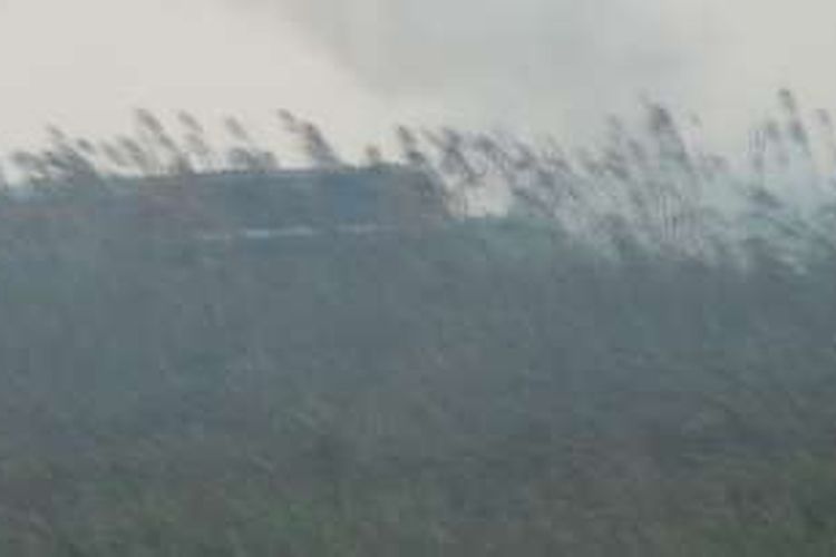 Kereta api meintas di tengah asap sisa kebakaran lahan di Desa Sungai Rambutan Ogan Ilir, kebakaran lahan tersebut mengancam perjalanan kereta api jika skalanya semakin besar