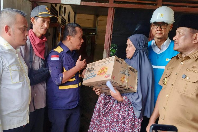 Menteri ESDM, Bahlil Lahadalia (ketiga dari kiri) didampingi Bupati Bireuen, Mukhlis (kanan), dan Direktur Utama PLN, Darmawan Prasodjo (kedua dari kanan) memberikan bantuan sembako kepada salah satu warga terdampak banjir di Desa Blang Panjo, Kabupaten Bireuen, Aceh, Selasa (2/12/2025).