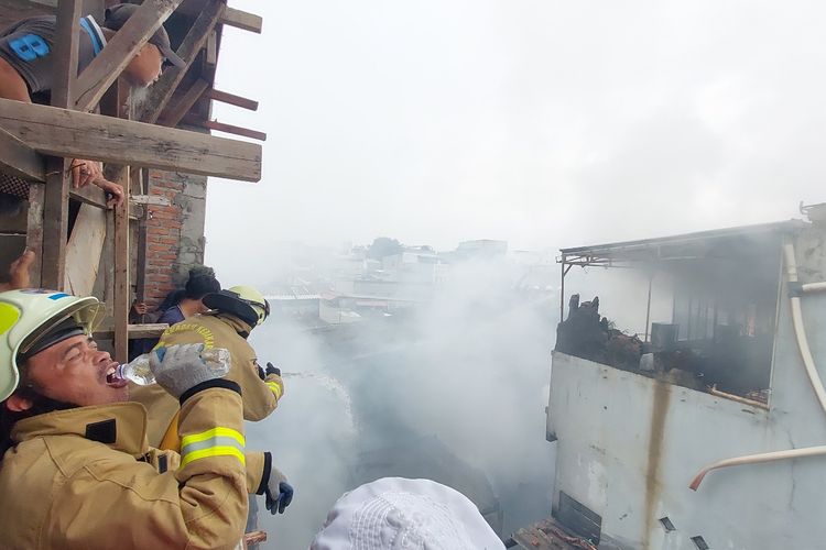 Potret perjuangan petugas pemadam kebakaran di tengah kebakaran di pemukiman warga di belakang Mall Seasons City Jalan Jembatan Besi, Kecamatan Tambora, Jakarta Barat, Jumat (1/4/2022) siang.