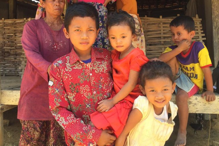 Ismail, siswa SDN Palenggiyan 1 Kedungdung Sampang, menggendong adiknya yang biasa ikut setiap hari ke sekolahnya. Di sekolah ia tidak hanya belajar, tapi juga mengasuh kedua adiknya. 