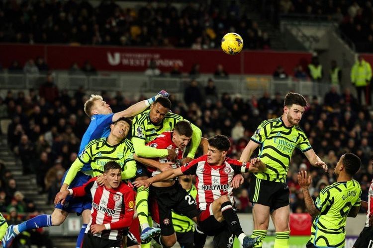 Kiper Arsenal, Aaron Ramsdale, meninju bola pada laga lanjutan Premier League atau Liga Inggris Brentford vs Arsenal yang bergulir di Stadion G Tech Community, London, pada Minggu (26/11/2023) dini hari WIB.