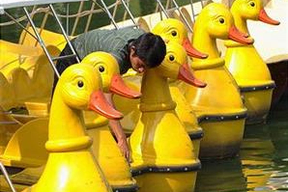 Seorang pekerja membersihkan perahu bermodel bebek di salah satu tempat wisata di Bangkok, Thailand. Pemerintah Thailand getol mempromosikan pariwisata, salah satunya dengan konsep One Tambon One Product atau OTOP.