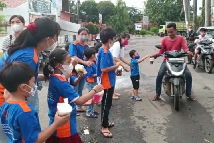 Sejumlah siswa-siswi Taman Kanak-kanak dan Sekolah Dasar Buddha Asoka Manggala Kota Cirebon, membagikan takjil kepada warga yang melintas, Senin (27/3/2023)