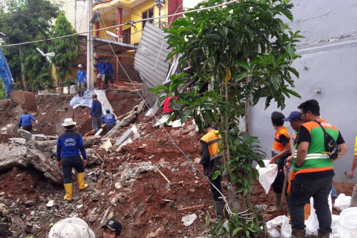 Petugas dari Sudin Sumber Daya Air Jakarta Timur, Sudin Bina Marga Jakarta, dan PPSU melakukan pembersihan di lokasi longsor Jalan Pesona IX, Kalisari, Pasar Rebo, Jakarta Timur, Selasa (27/11/2018)