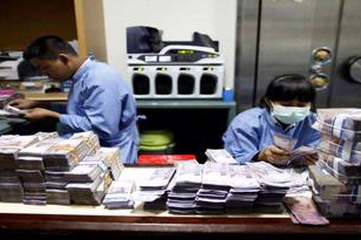 Petugas menyortir uang pecahan Rp. 10.000 di Sentra Operasi Kas (SOK) di kantor BRI Pusat di Jakarta, Rabu (28/3/2012). 